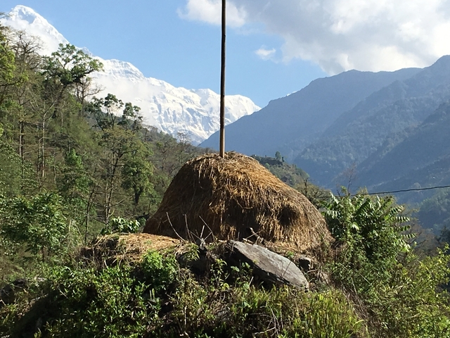 Snow-capped mountains with a haystack in the foreground.