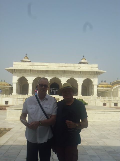 Two men in front of a white marble building.