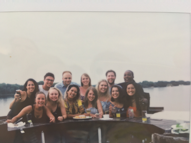 Group photo with people sitting at a riverside, but image is blurry.