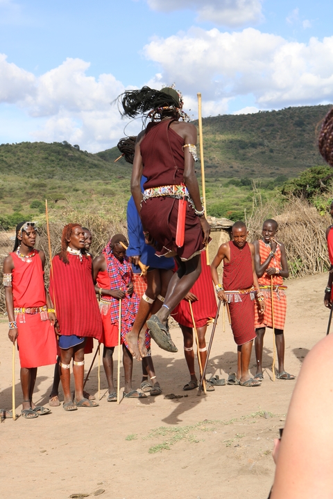 Local people in traditional attire, one jumping in the air.