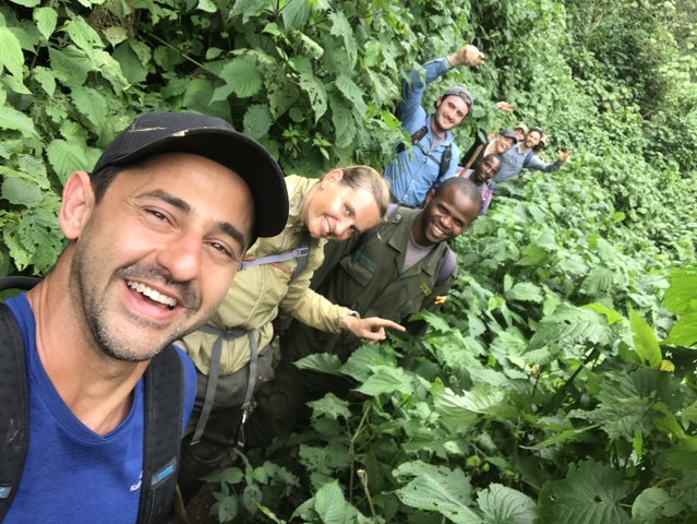 Group of people smiling in a lush forest setting.
