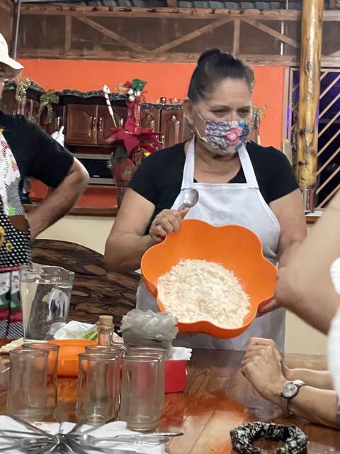       Person holding an orange bowl with flour in a kitchen setting.
  
