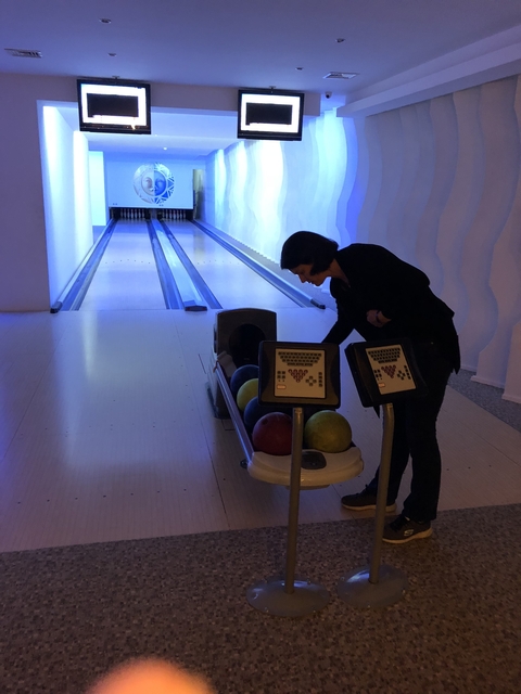 Person at a bowling alley, preparing to bowl.