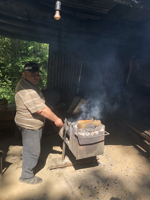       Person grilling meat outdoors.
  
