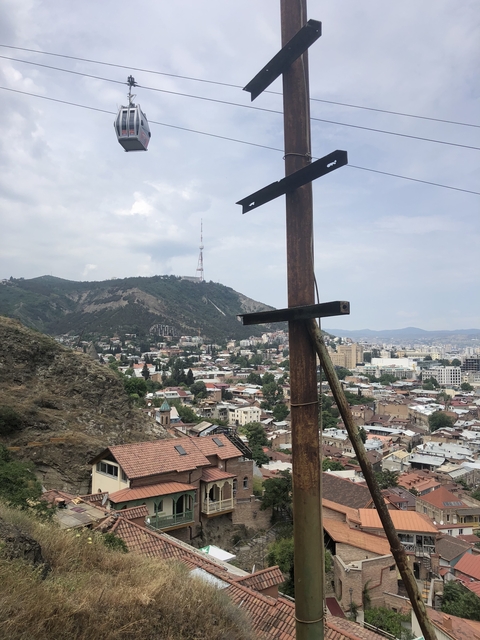 Cityscape with a mountain and telecommunications tower.