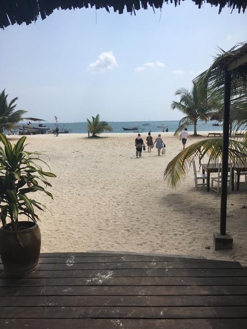A beach scene with people walking towards the ocean.