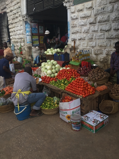 A busy market stall with a variety of fresh vegetables.