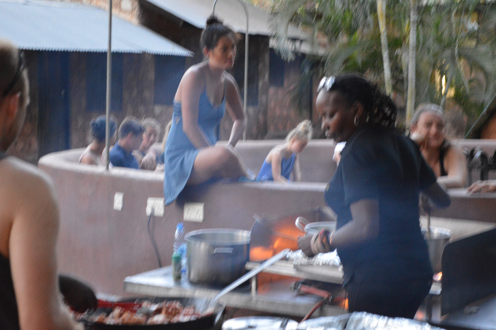Blurry image of people gathering around a cooking area.