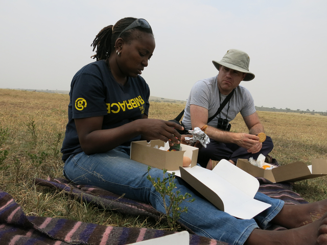 Two people having a picnic in a grassy field.