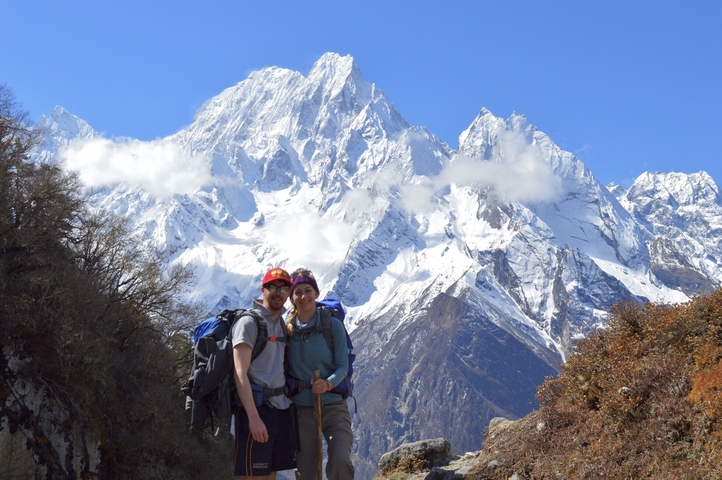 Couple posing with snow-capped mountains in the background.