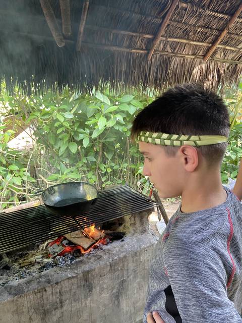 Person observing an outdoor cooking area with a fire pit.