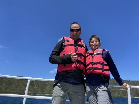 Two people wearing life vests on a boat.