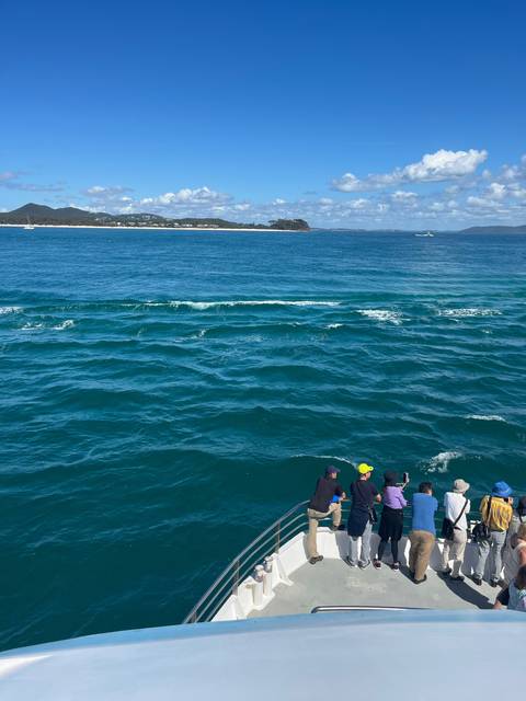 Group of people on a boat experiencing the ocean's movement.