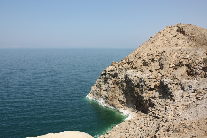       Rugged cliff face overlooking a vast body of water.
  