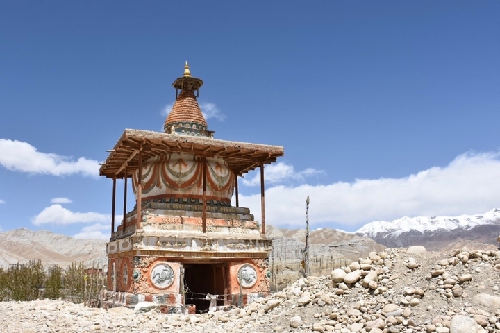 Buddhist stupa with mountains in the background.