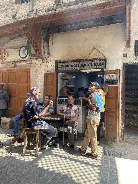 People sitting and talking outside a shop