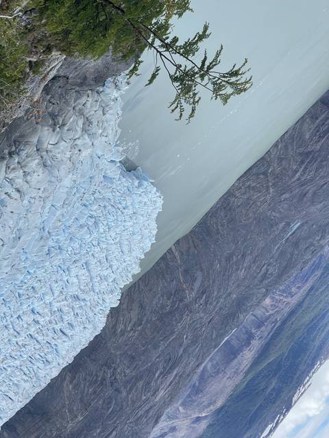       Aerial view of a glacier meeting a lake.
  