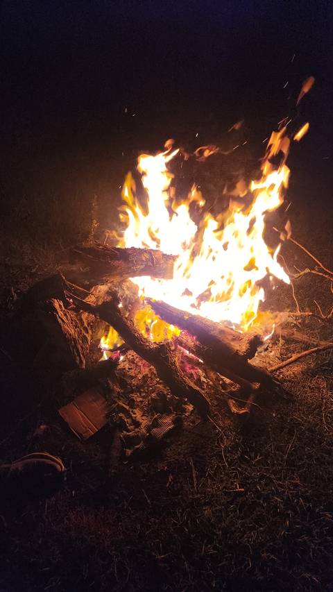 Campfire burning brightly at night.