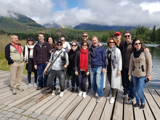 Group of people on a wooden deck near a lake in Slovakia.