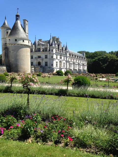       A chateau with a garden in front of it.
  