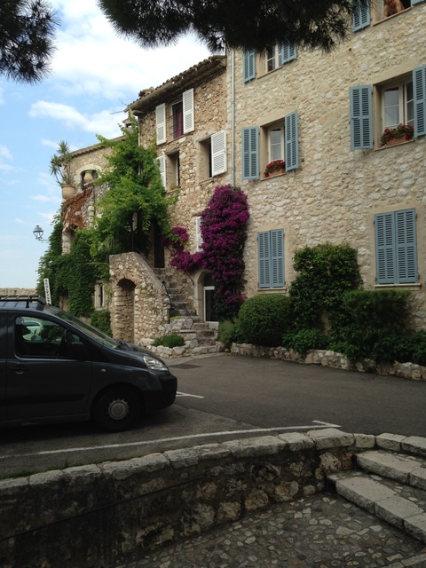       Traditional stone house with colorful plants.
  