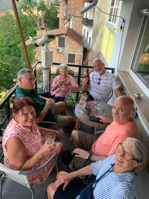 Group of people enjoying drinks on a balcony