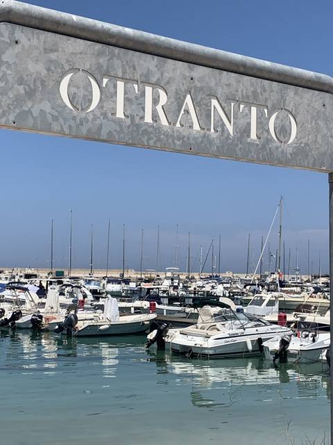 Otranto sign near a harbor with boats.