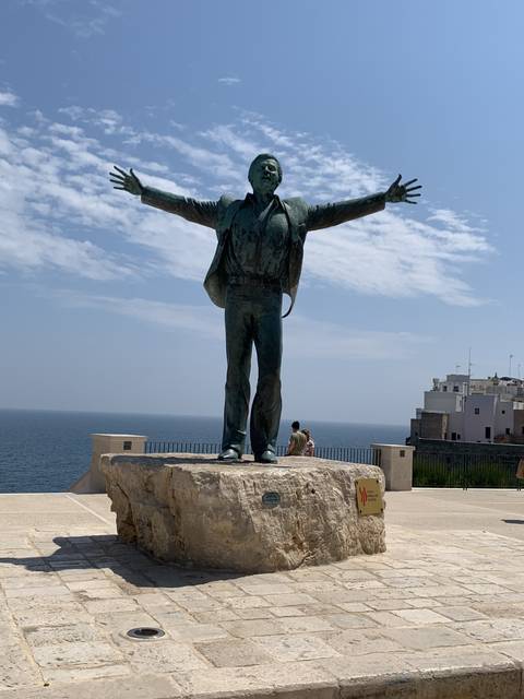 Statue by the sea with open arms.