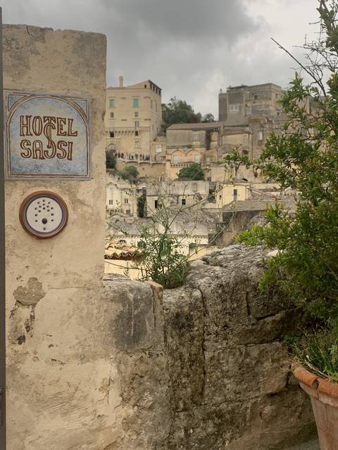       View of Matera cityscape with houses and stone walls.
  
