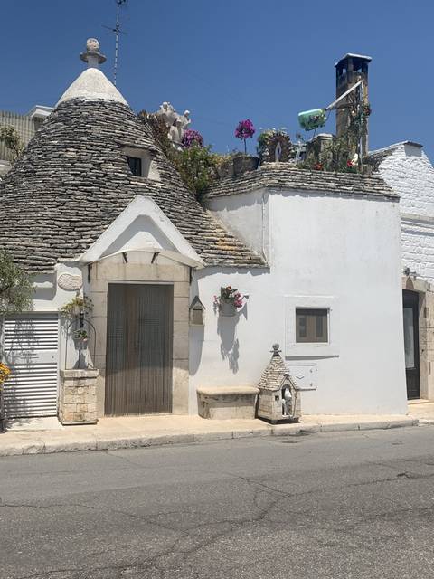 Traditional trulli houses with stone roofs and white walls.