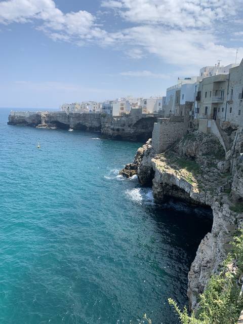       Coastal town with white buildings on cliffs by the sea.
  