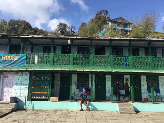 Two people in front of a building with vibrant blue and green paint.