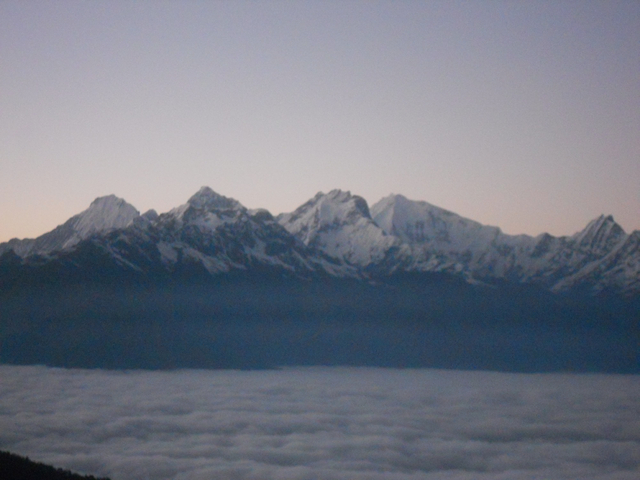 Blurry image of snow-capped mountains under a clear sky.