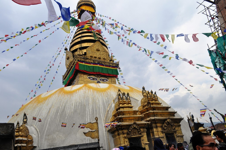       Majestic stupa with vivid prayer flags against the sky.
  