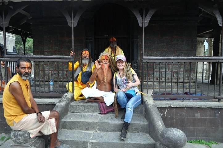       Group of people with a sadhu in front of a temple.
  