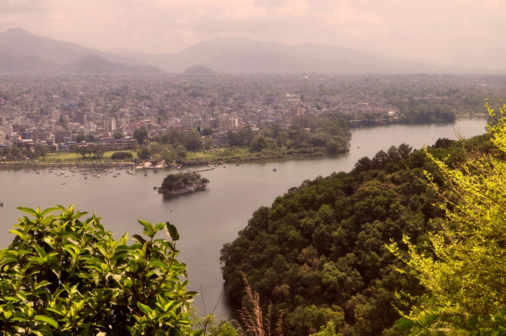       Aerial view of a lake with a city in the background.
  