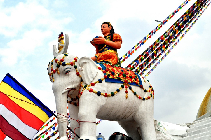 White elephant statue with a woman figure and colorful decorations.
