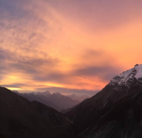       A vibrant sunset illuminating snow-covered mountain peaks.
  
