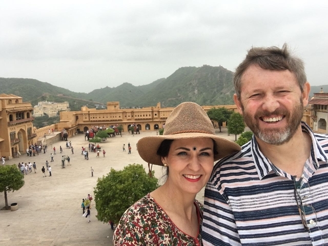       Couple taking a selfie with a fort and hills in the background
  