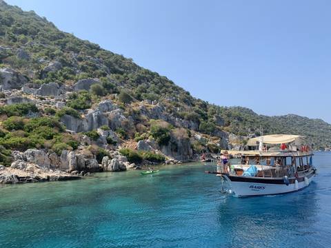       Scenic coastal view with a boat cruising near rocky terrain.
  