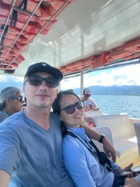 Group of people on a boat ride with a scenic mountain view.