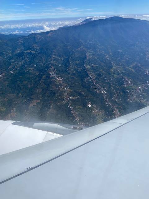 Aerial view of landscape with airplane wing.