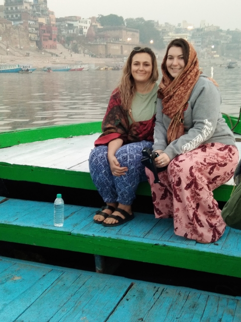 Two people sitting on a boat on a lake.