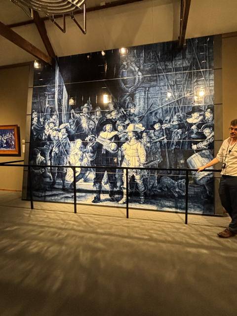       Large tiled artwork depicting a traditional scene in a museum.
  