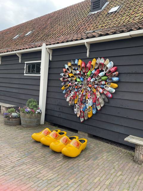       Wall with a variety of colorful wooden clogs displayed.
  