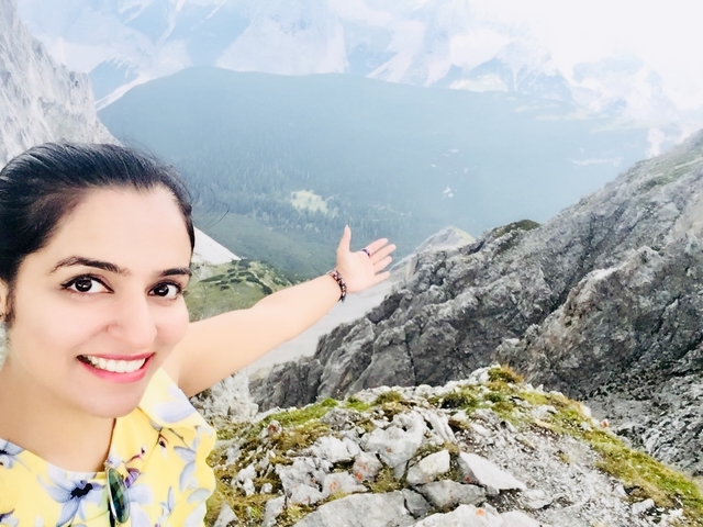 Selfie of a woman on a rocky mountain with scenic view.
