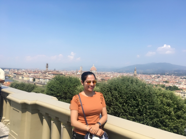 Woman posing with a panoramic view of a city and cathedral.