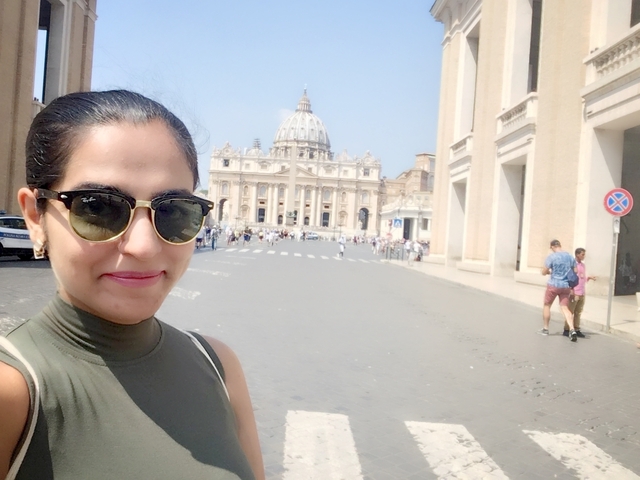 Woman taking a selfie with a famous European building in the background.
