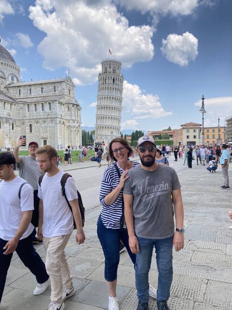 Group of people with the Leaning Tower of Pisa in the background.