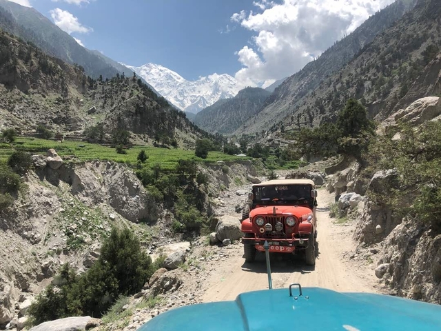       Jeep traveling on a mountainous dirt road with scenic views.
  